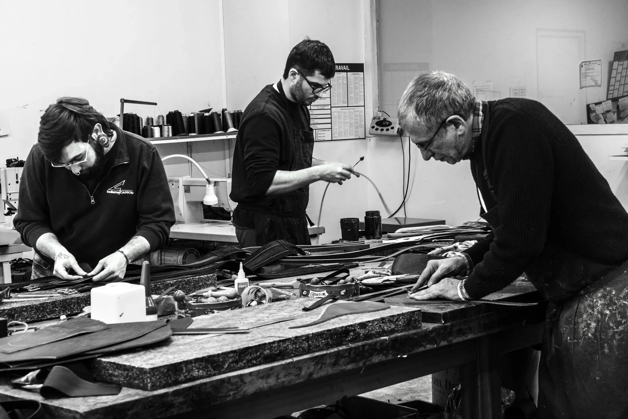 Trois artisans au travail autour de l’établi de la Sellerie Cassou à Bénéjacq