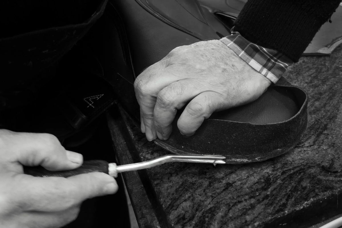 Geste de reprise d’une pièce de cuir sur une selle dans l’atelier Cassou
