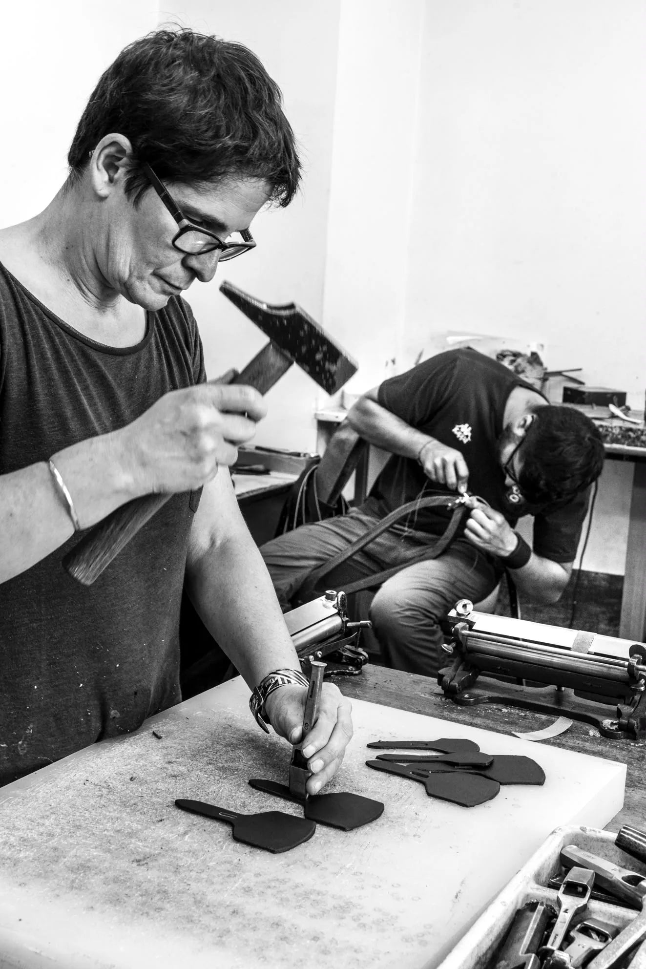 Découpe de pièces en cuir à la main dans l’atelier Sellerie Cassou, photographie en noir et blanc